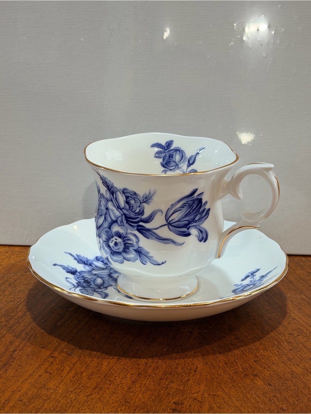 White Porcelain Teacup and Saucer with Blue Floral Pattern and Gold Trim